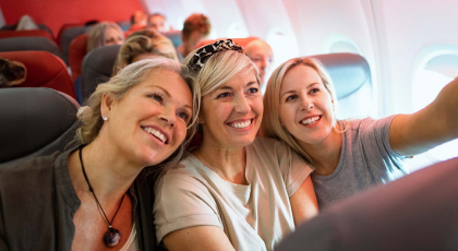 Three women taking a selfie on a plane
