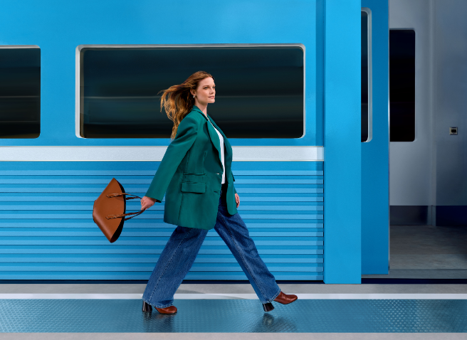 Two women hugging and a third women looking at them and smiling