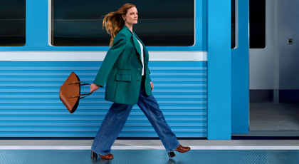 Two women hugging and a third women looking at them and smiling